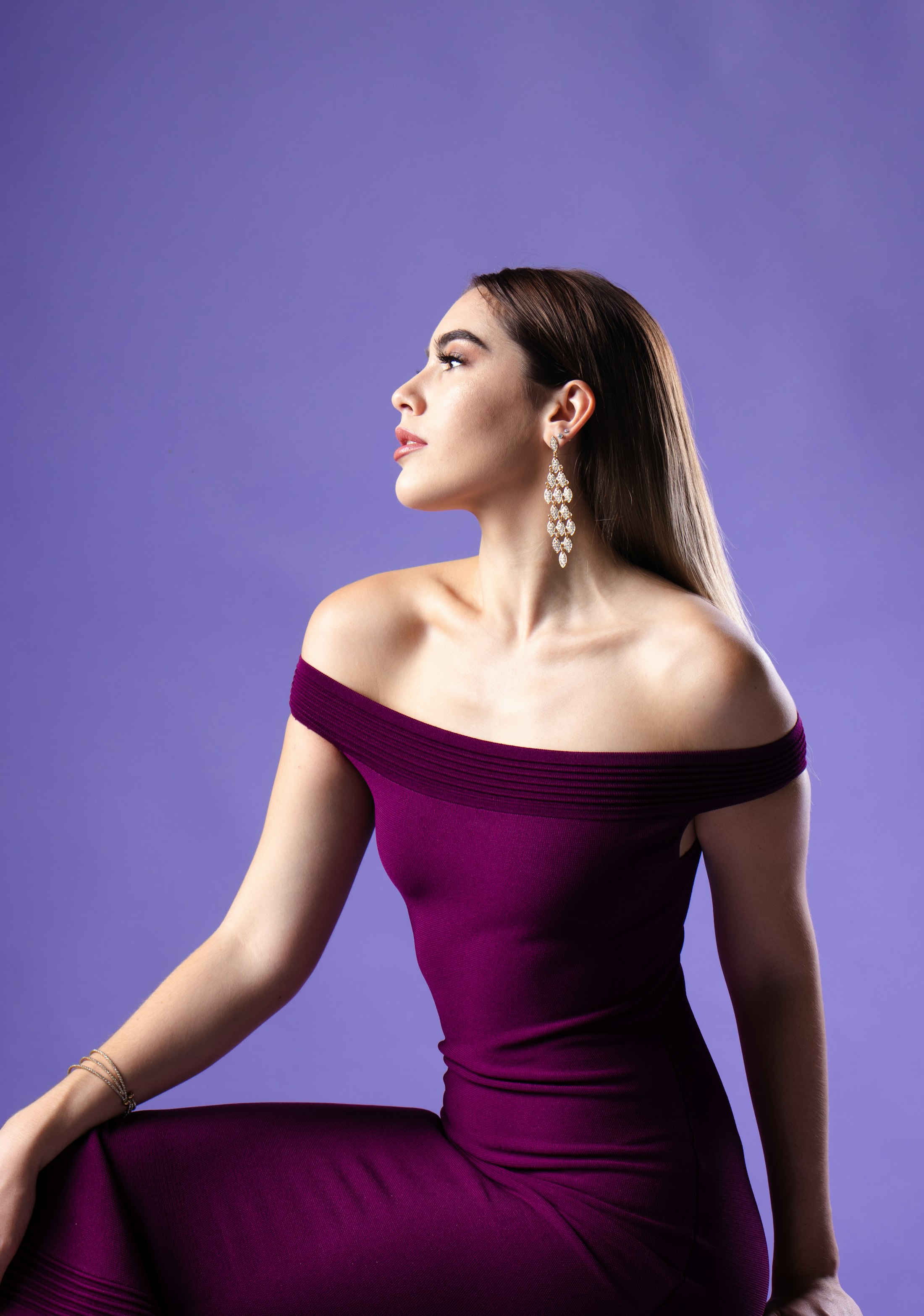 Mannequin en robe pourpre épaules dénudées sur fond violet